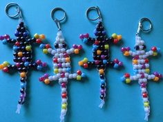 three beaded keychains are sitting on a blue surface