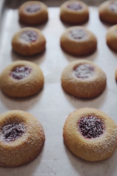 several cookies with powdered sugar on them are lined up in a baking pan and ready to be baked