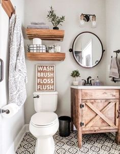 a white toilet sitting in a bathroom next to a wooden cabinet and mirror on the wall