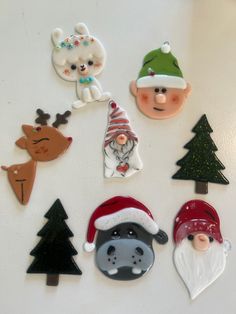 various christmas decorations are displayed on a white surface in the shape of santa claus, snowman, and reindeer