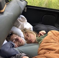 two people sleeping in the back of a truck