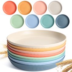 a stack of plates with different colors on them and wheat stalks in the foreground