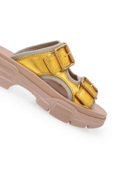 These Gucci leather sandals make a casual essential that's elevated with an outdoor-inspired vibe. This slide-sandal hybrid is designed with metallic double leather straps, a technical canvas lining, and a chunky, oversized rubber sole.Open toeBuckle fasteningChunky heel.Composition: Calf Leather 100%, Polyamide 100%Lining: Polyamide 100%, Polyurethane 100%Sole: Rubber 100%Made in Italy Trendy Gold Leather Sandals, Gucci Sandals With Buckle Closure And Open Toe, Gucci Open Toe Sandals With Buckle Closure, Modern Chunky Platform Slide Sandals, Gucci Sandals With Buckle Closure For Summer, Trendy Chunky Platform Slide Sandals, Casual Sandals With Lug Sole For Streetwear, Luxury Slides With Textured Footbed For Spring, Luxury Platform Slides For Summer