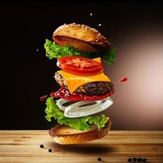 a hamburger is stacked on top of each other with tomatoes, lettuce and cheese