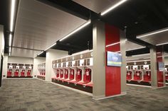 a row of red lockers sitting inside of a room filled with white and brown walls