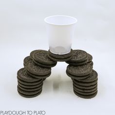 a stack of chocolate cookies sitting next to a white cup