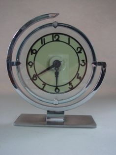 a glass clock sitting on top of a metal stand