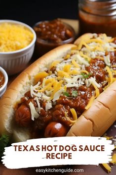 a hot dog covered in chili and cheese with other condiments on the side