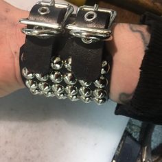 Black leather bracelet with two buckles and six rows of small cone studs. Punk Cuff Bracelets With Rivets, Punk Black Bracelet With Silver Studs, Black Leather Punk Bracelet With Silver Studs, Rock Style Leather Bracelet With Studs For Festivals, Black Leather Bracelets With Studs, Rock Style Studded Leather Bracelet For Festivals, Punk Leather Bracelet With Studs, Edgy Leather Bracelets With Rivets, Punk Style Studded Leather Bracelet