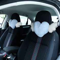 the interior of a car with two heart shaped pillows on it's headrests