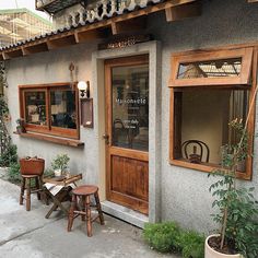 an outside view of a restaurant with wooden tables and stools in front of it