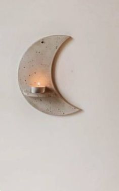 a wall light that is on the side of a white wall with a half moon