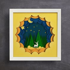 a paper cut out of a deer standing in the middle of a forest at night