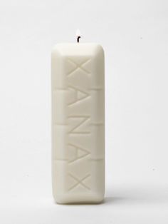 a white candle with the word xana written on it