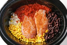 two fish fillets in a crock pot with beans, rice and corn on the side