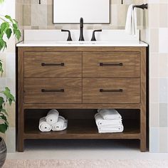 a bathroom vanity with two sinks and towels on the bottom shelf in front of it