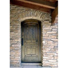 an old wooden door is shown in front of a stone wall