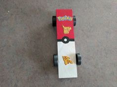 a skateboard with pokemon stickers on it sitting on top of the floor next to a pair of shoes