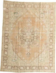 an antique rug with floral design on the center and border, in light brown tones