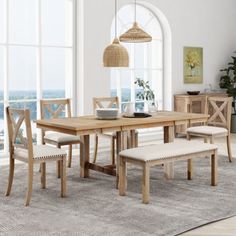 a dining room table with bench and chairs in front of large windows overlooking the ocean