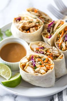 several burritos on a plate with dipping sauce