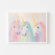 three pastel unicorns with yellow, pink, and blue manes on a white background