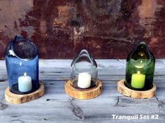 three small candles are sitting in glass bottles