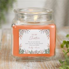 a small jar filled with an orange candle