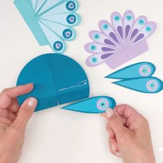 someone is cutting out some paper with scissors and other things to make it look like a peacock