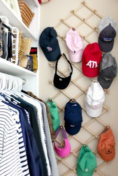 several hats are hanging on a rack in the closet