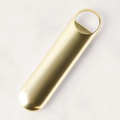 a gold metal object on a white surface