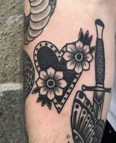 a black and white photo of a tattoo on someone's arm with a knife