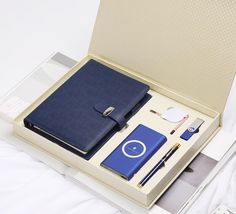 an open box containing a notebook, pen and other items