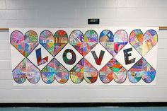 a bulletin board with the word love written in many different colors and shapes on it