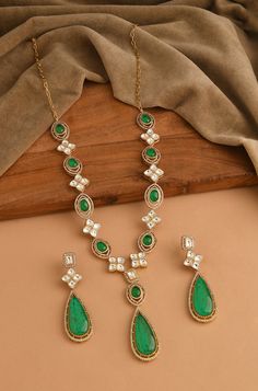 This modern interpretation of late Victorian art is a masterpiece of elegance and charm. Adorned with intricately cut polkis, cubic zirconia, and mint green crystals, this Necklace Set captures the essence of the period's glory while adding a touch of finery and glamour to any outfit Finish: 22KT Gold Plating Material: Silver, Copper Alloy, Polki Color: Mint Size: Free Size, Adjustable Closure Type: Lobster Box Contains: 1 Necklace, 1 Pair Earrings Emerald Necklace With Stone Work For Gift, Elegant Emerald Kundan Necklace With Stone Work, Elegant Emerald Jewelry With Stone Work, Elegant Kundan Necklace With Emerald Stone Work, Elegant Emerald Necklace With Stone Work, Green Gemstone Diamond Necklace For Wedding, Green Diamond Necklace With Gemstones For Wedding, Elegant Emerald Necklace With Stone Work As Gift, Elegant Green Emerald Necklace With Stone Work