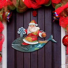 a christmas wreath with a santa clause on it and a whale in front of the door