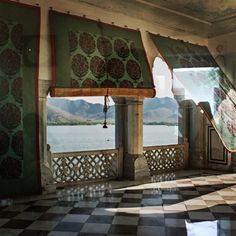 an ornate room with black and white checkerboard flooring, windows covered in green curtains