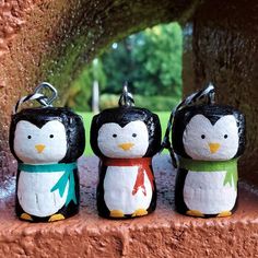 three small penguin figurines are sitting on a ledge