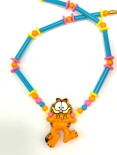 an orange and blue beaded necklace with a cartoon character on it