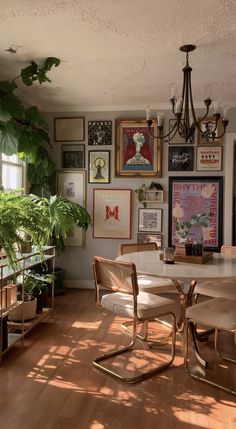 a dining room table with chairs and pictures on the wall in front of it's windows