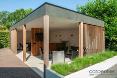 an outdoor living area with wooden slatted walls and green grass on the ground