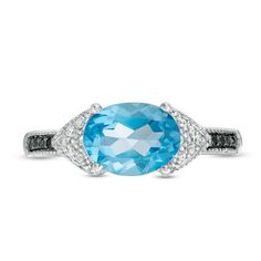 Modern design meets vintage inspiration in this dazzling gemstone ring. Fashioned in sterling silver, this unique look showcases a 9.0 x 7.0mm oval-shaped sky-blue topaz flanked by chevron-shaped collars lined with sparkling white diamonds and intricate milgrain detailing. The shank glistens with alluring enhanced black diamonds wrapped in milgrain borders. Radiant with 1/15 ct. t.w. of diamonds and a brilliant buffed luster, this style is certain to be noticed. Custom-made to fit her ring size. Sterling silver rings cannot be resized after purchase. Oval Topaz Ring With Diamond And Gemstone Accents, Oval Blue Topaz Ring With Diamond Accents, Oval Blue Topaz Diamond Ring With Accents, Oval Sapphire Topaz Ring With Diamond Accents, Oval Topaz Ring With Diamond Accents, Oval Topaz Ring With Gemstone Accents, Classic Topaz Ring With Gemstone Accents For Promise, Classic Sterling Silver Topaz Ring With Gemstone Accents, Classic Topaz Ring With Gemstone Accents