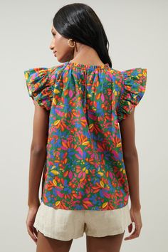 Spruce things up in this vibrant, tropical floral print. It works to shape the evergreen, Risette top. A flirty, lightweight blouse that features ruffled cap sleeves. They frame a split neckline and the top maintains a relaxed bodice that can be worn tucked in or out. Wear it with your favorite denim and fun sandals to compliment the look.- Lightweight- Split neckline- Cap sleeves- Relaxed fit- Color: Kelly MultiSize + Fit - Model is 5'10" and wearing size XS- Measurements taken from size S - Ch Multicolor Cotton Ruffle Sleeve Tops, Multicolor Cotton Top With Ruffle Sleeves, Multicolor Cotton Tops With Ruffle Sleeves, Multicolor Cotton Blouse With Ruffle Sleeves, Multicolor Cotton Flutter Sleeve Top, Summer Multicolor Print Ruffled Tops, Green Ruffle Sleeve Top With Floral Print, Green Top With Ruffle Sleeves And Floral Print, Fitted Tropical Tops For Spring