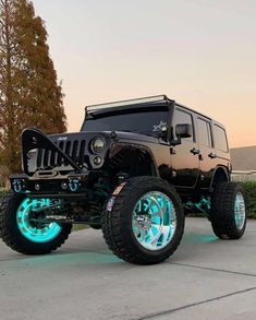 a black jeep with blue lights on it's tires