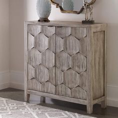 a wooden cabinet sitting in front of a mirror on top of a wall next to a rug