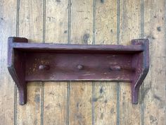 an old wooden shelf with three knobs on it