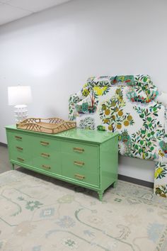 a green dresser sitting next to a bed in a room with white walls and carpet