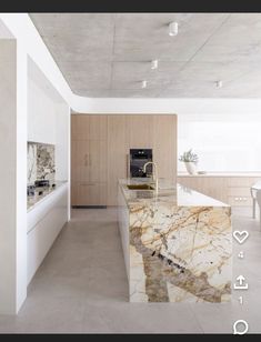 a large kitchen with marble counter tops and white cabinets, along with an island in the middle