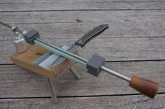 a wooden bench with tools on it and a knife sharpener attached to the handle