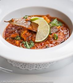 a white bowl filled with food and garnished with cilantro on top